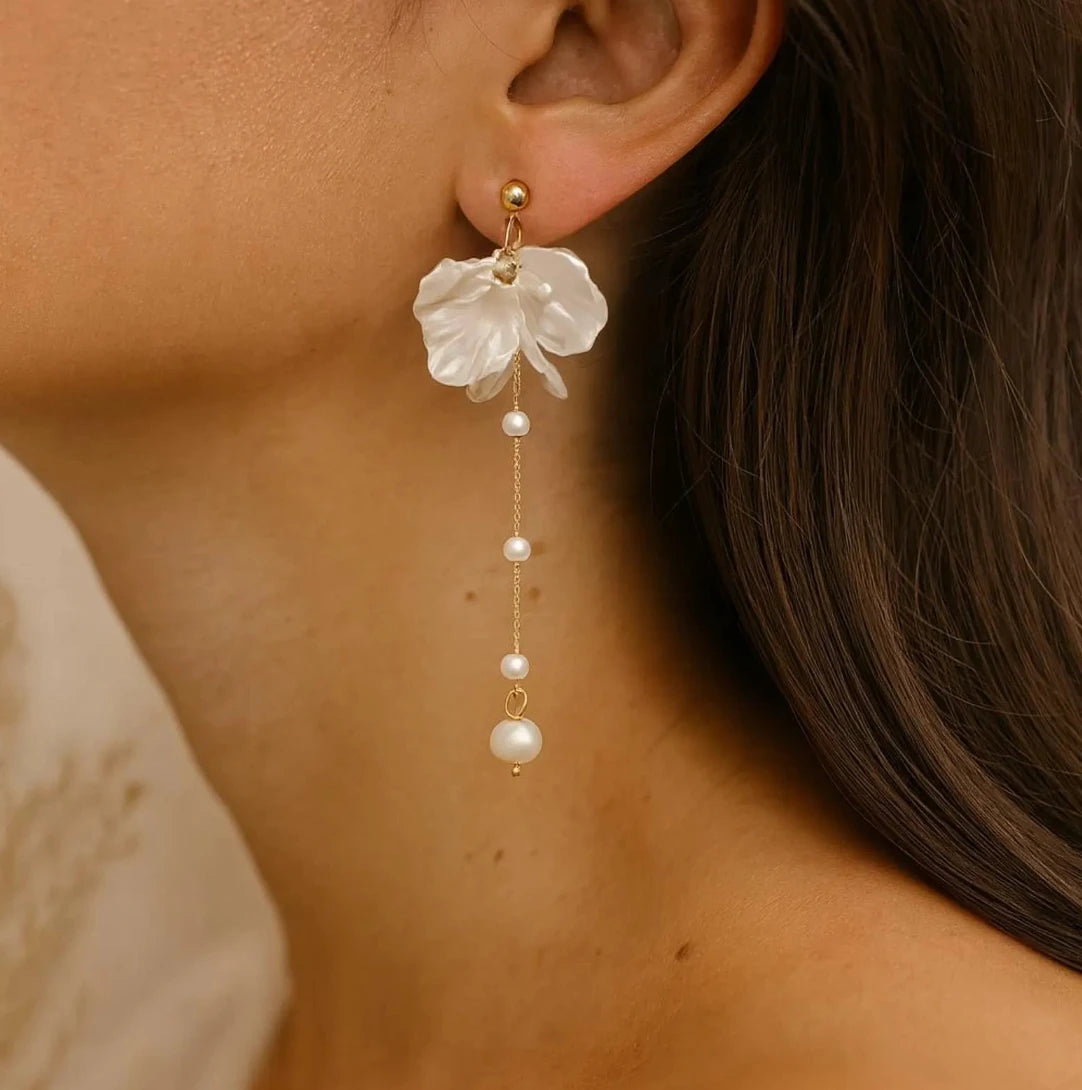 Close-up of a woman wearing floral earrings with pearl drops.